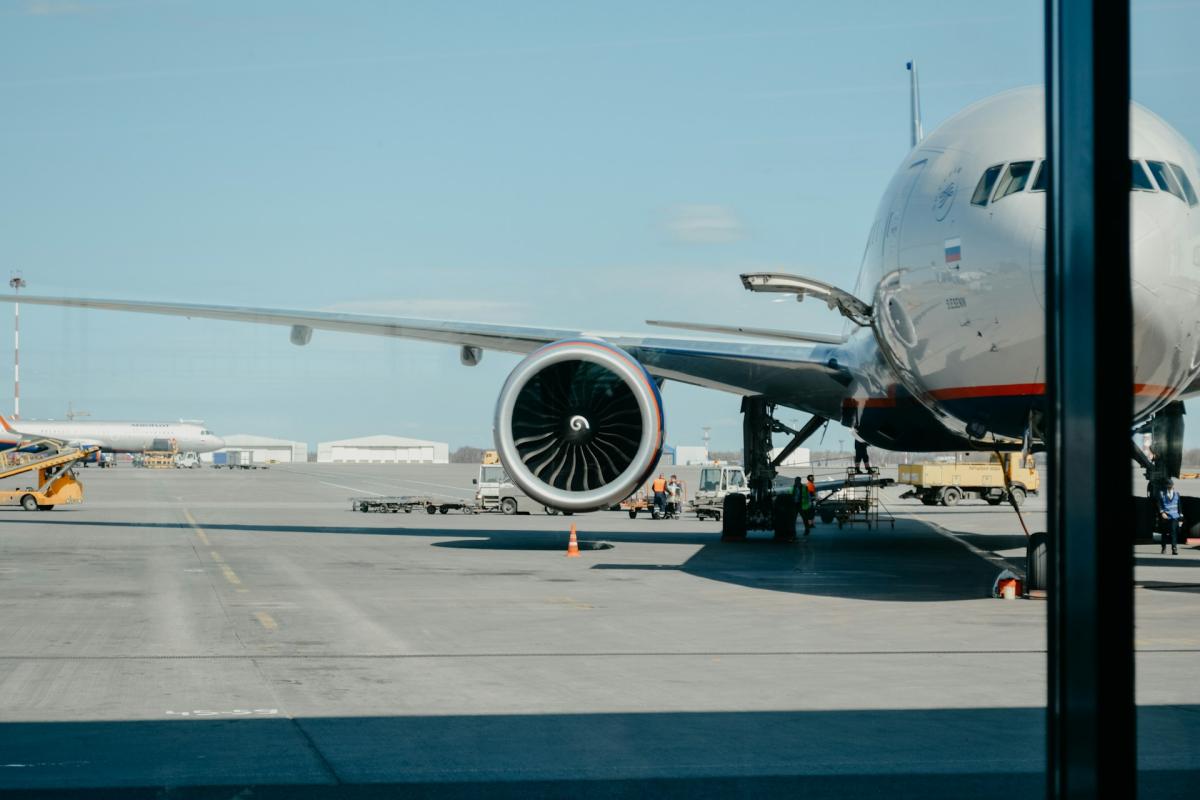 Elegant private jet terminal lounge with floor to ceiling windows overlooking aircraft on the ramp